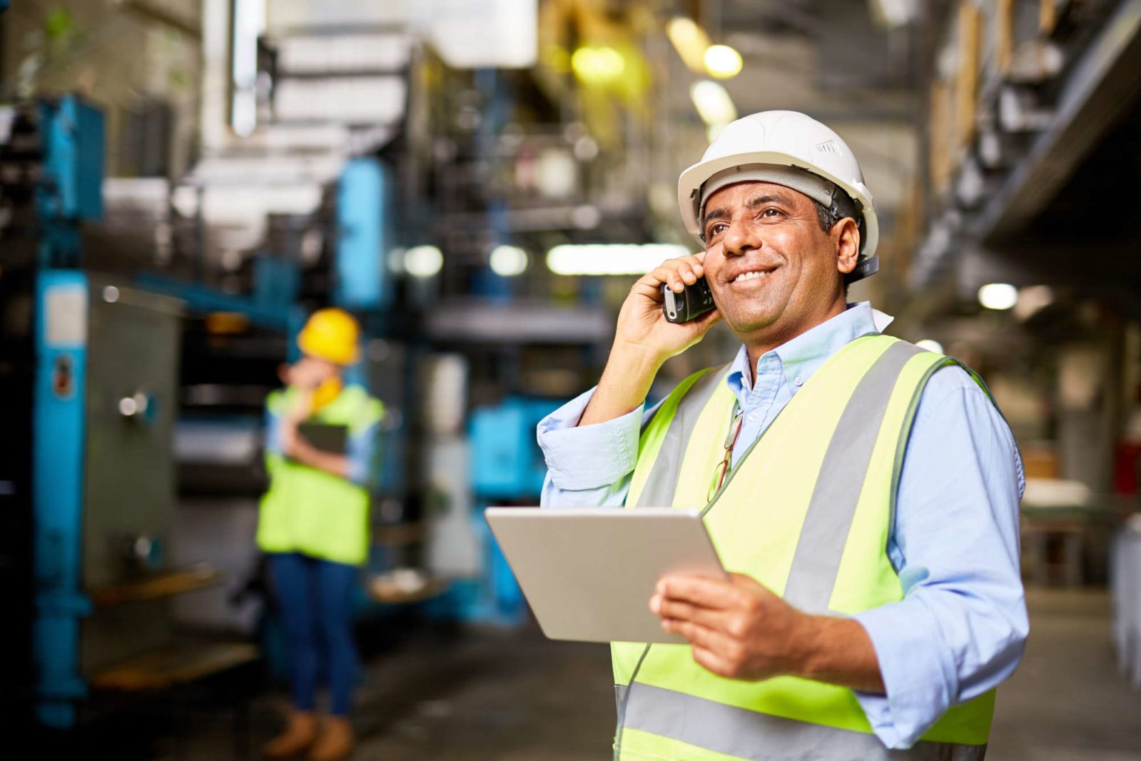 manufacturing manager holding a tablet talking on the phone
