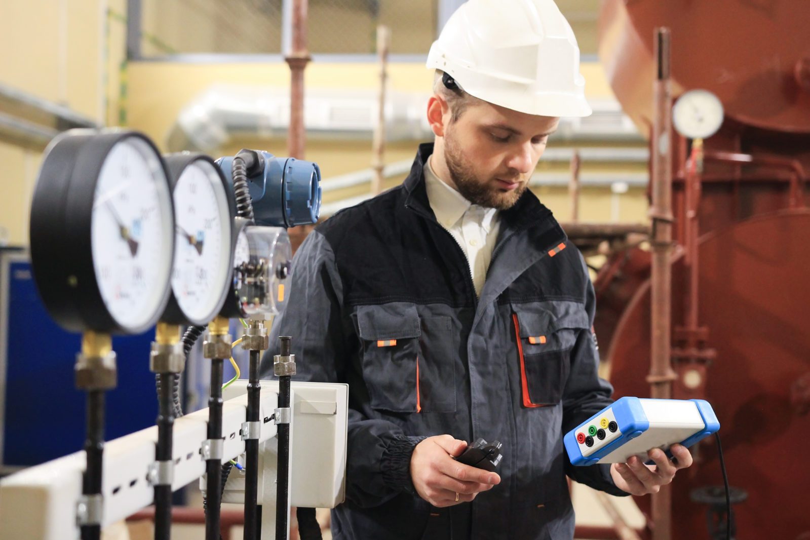 Technician operator measuring value of pressure, temperature and flow on gas and oil processing platform to monitor quality of process.