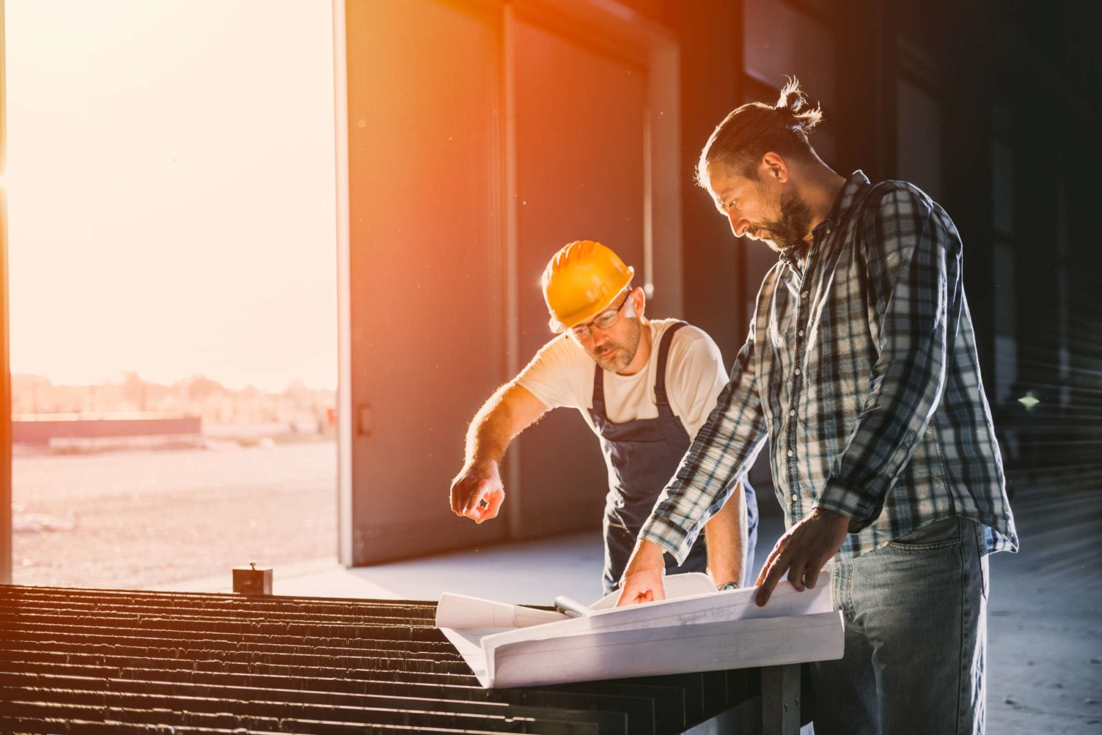 Construction workers checking checking blue print