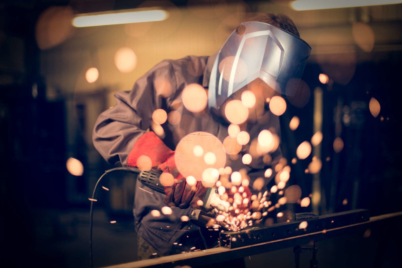 Employee grinding steel with sparks