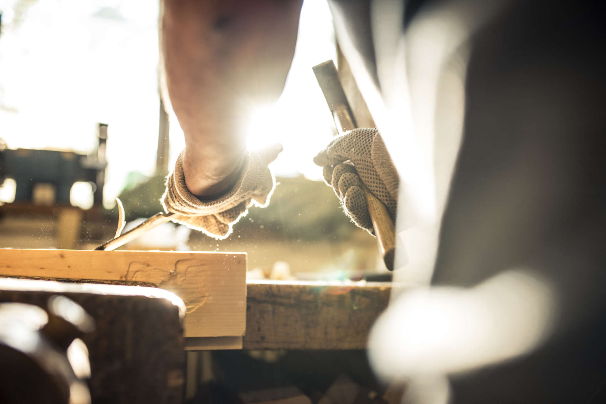 carpenter working in his shop chipping away at a board