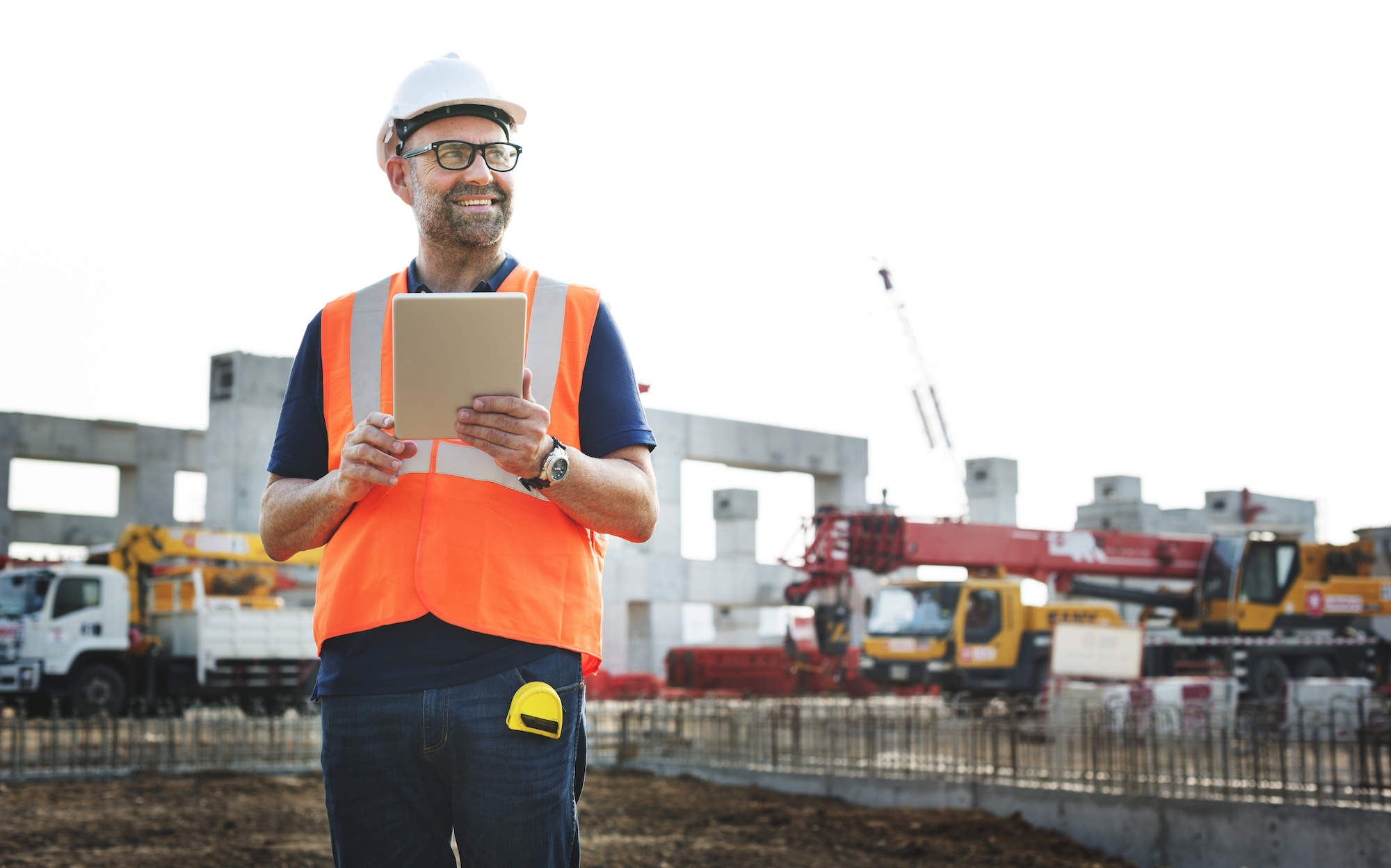 man on construction site holding notepad