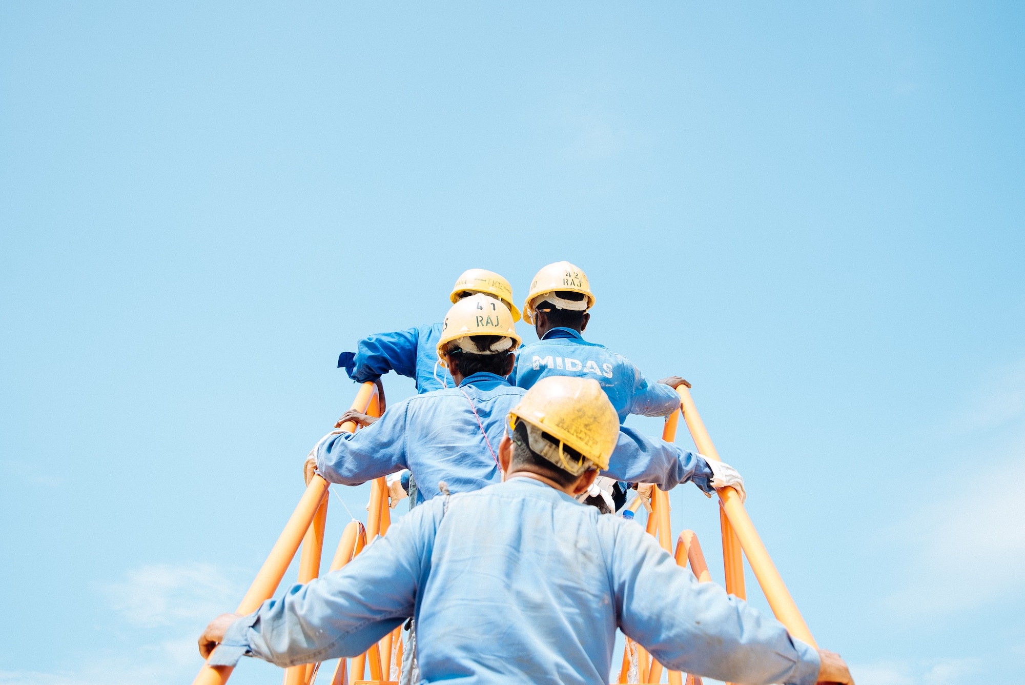 construction workers climbing yellow ladder