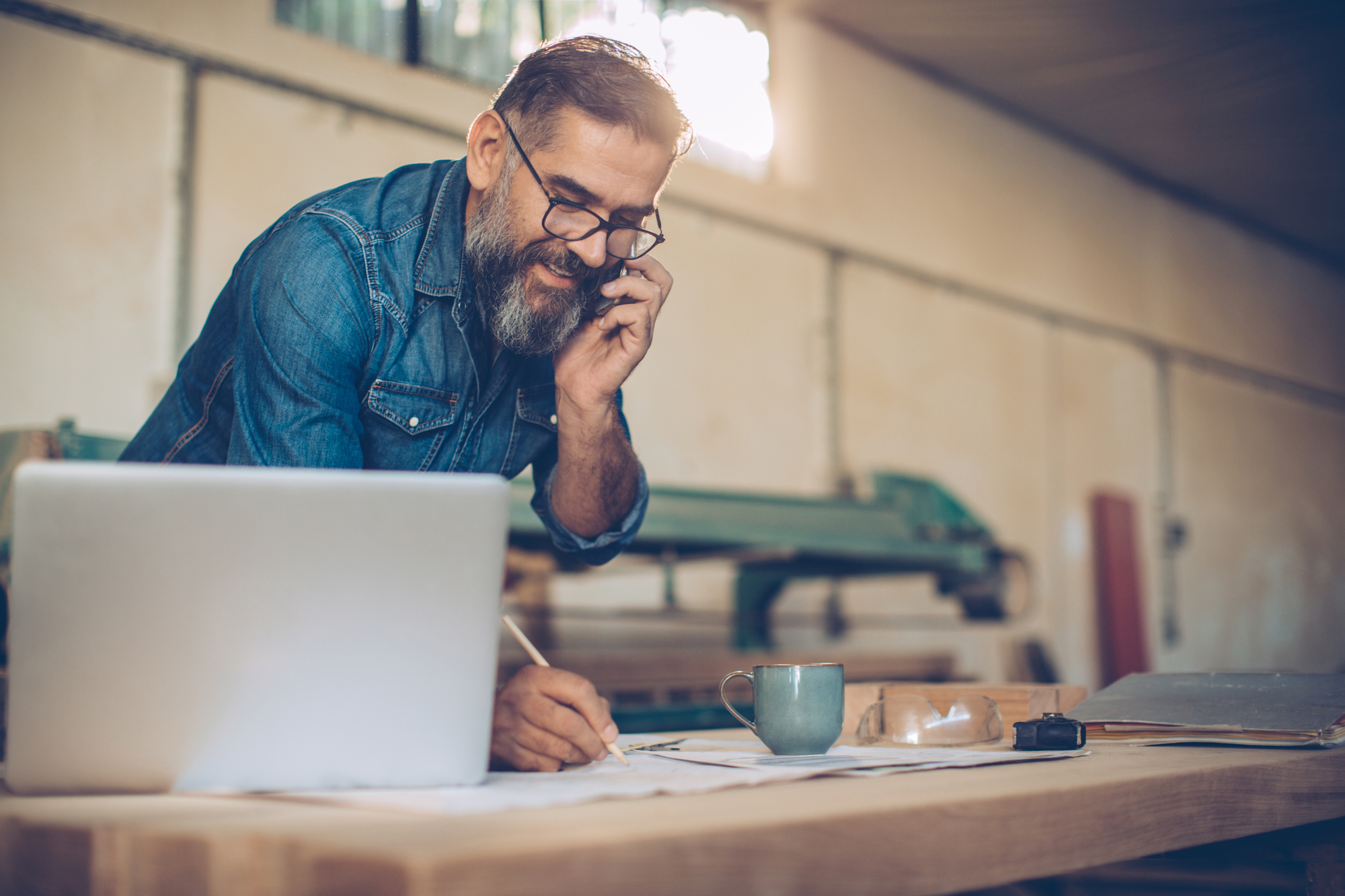 man talking on phone taking notes