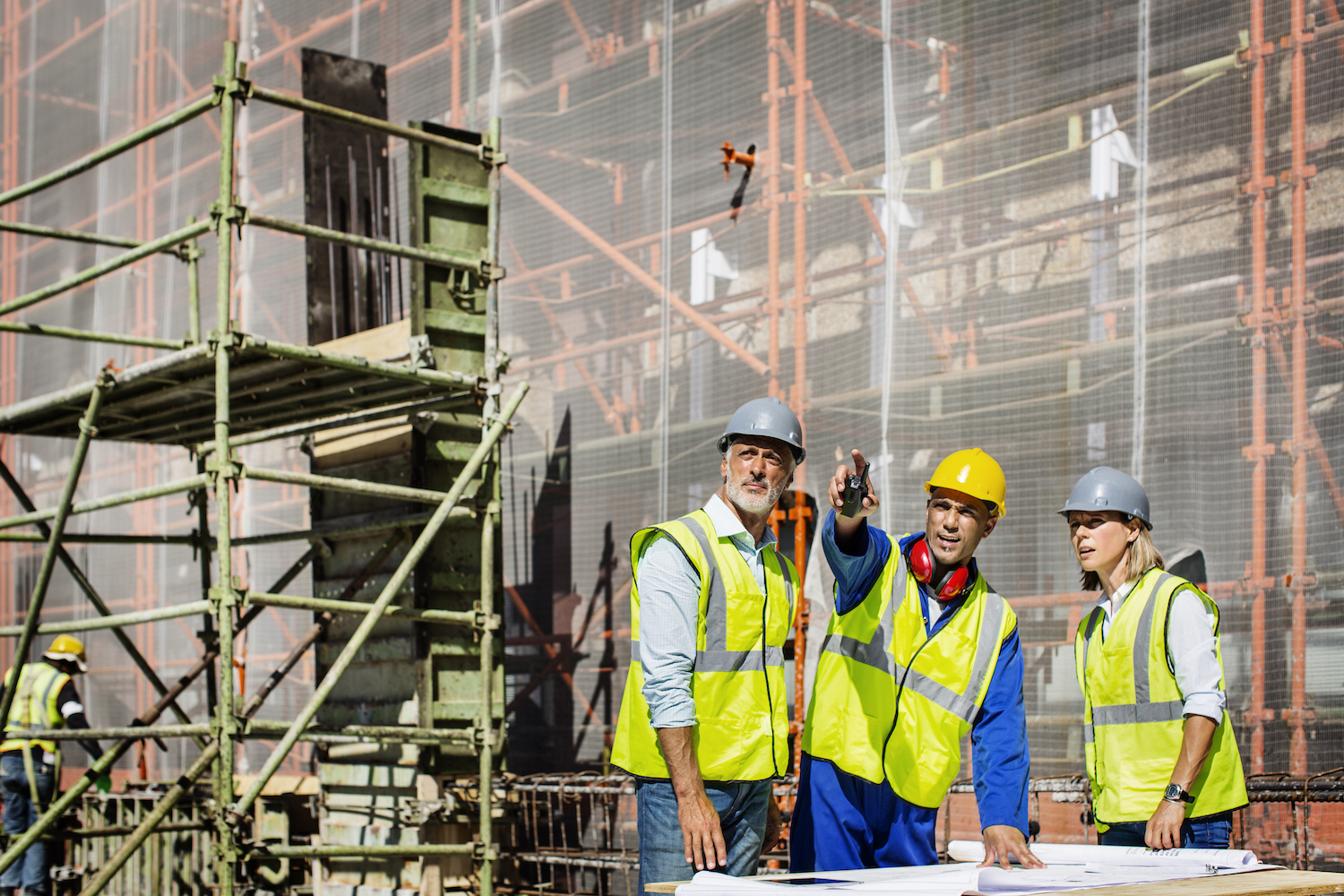 men and women construction workers pointing on job site