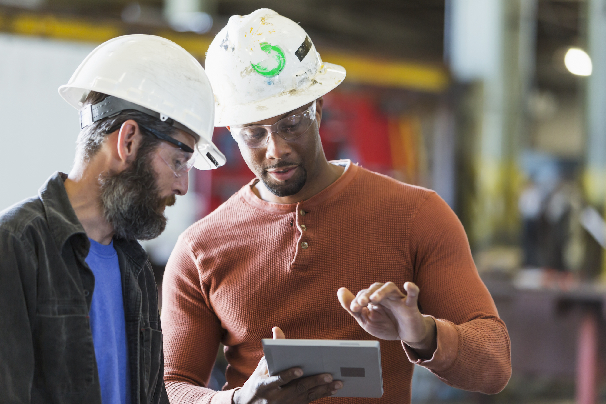 two skilled workers looking at tablet